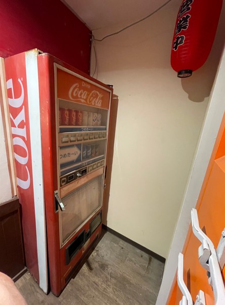 mugenPARKへはこの自動販売機の扉を開けて３階へ上がります。