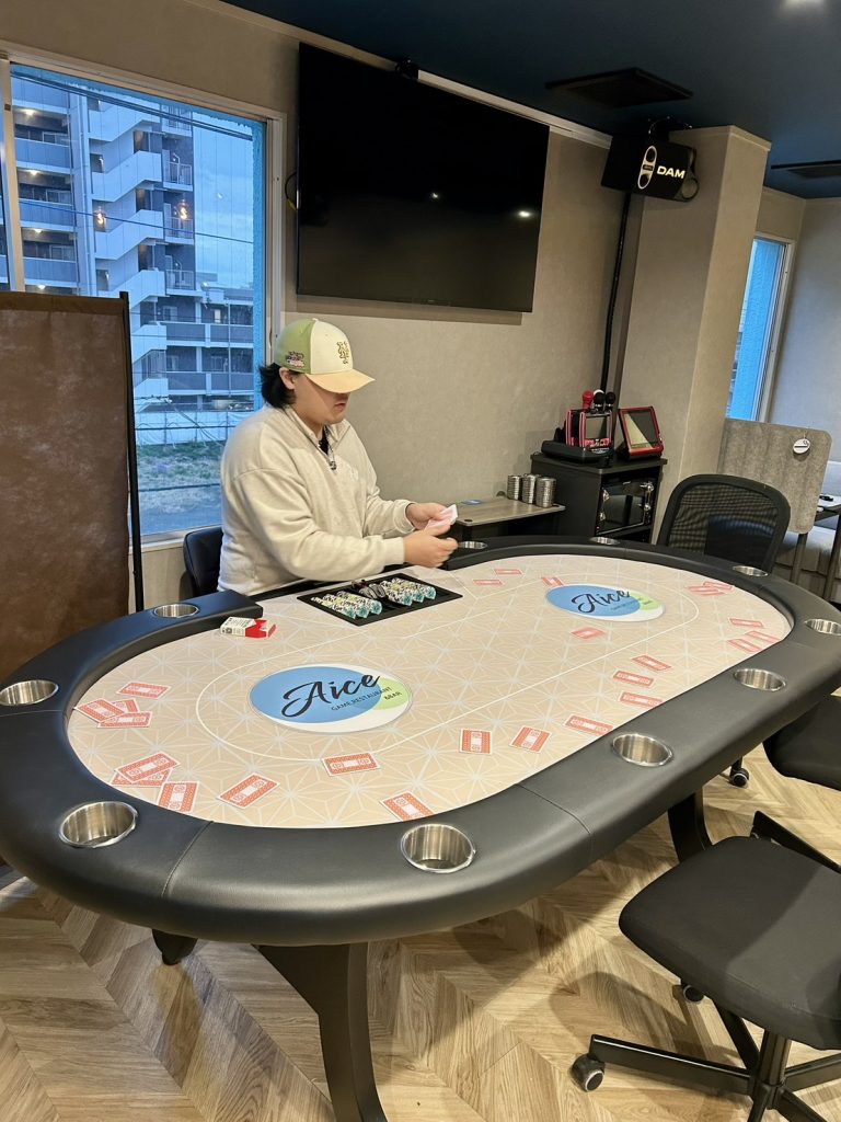 ポーカーテーブルでカードを配る練習するスタッフ